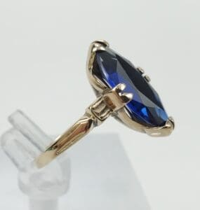 Gold ring with large blue gemstone.