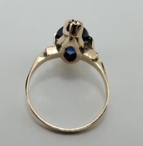 Gold ring with dark gemstone setting.
