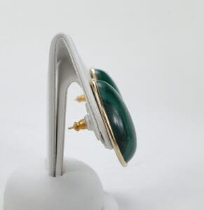 Green gemstone earrings on display stand.
