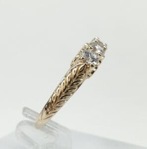 Gold ring with diamond and leaf design.