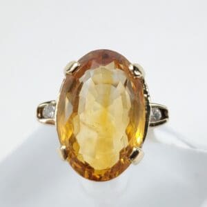 Gold ring with large oval yellow gemstone.