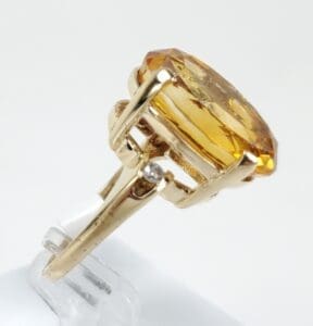 Gold ring with large yellow gemstone.