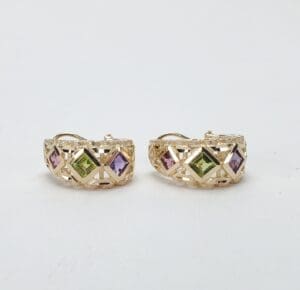 Gold hoop earrings with colorful gemstones.
