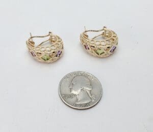 Gold hoop earrings with gemstones and quarter.