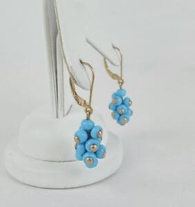 Gold earrings with blue beaded clusters.