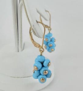 Blue beaded earrings on display stand.