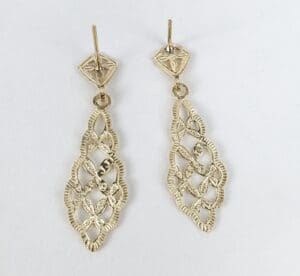 Gold filigree drop earrings on display.