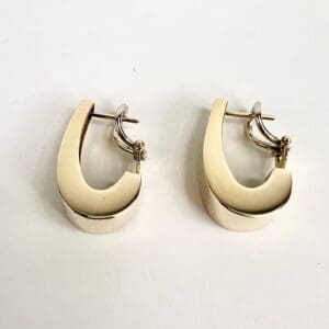Gold hoop earrings on white background.