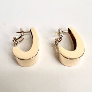 Gold hoop earrings on white background.