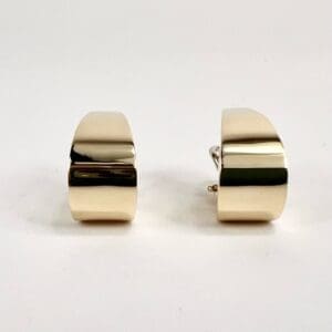 Gold rectangular cufflinks on white background.