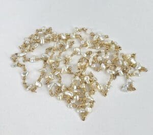 Pearl and gold chain on white background.