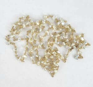 Gold wire necklace with white pearls.