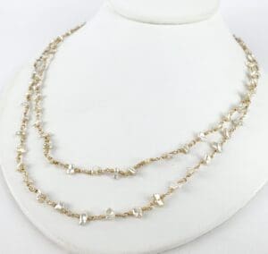 Gold chain necklace with pearl accents.