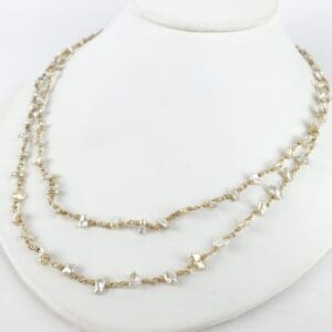 Gold chain necklace with pearl accents.