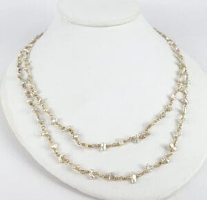Gold chain necklace with pearls on display.