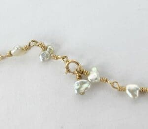 Gold wire bracelet with white pearls.