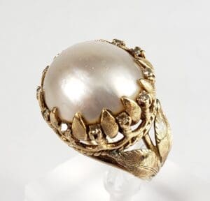 Gold ring with a large pearl centerpiece.