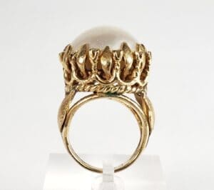 Gold ring with ornate pearl setting.