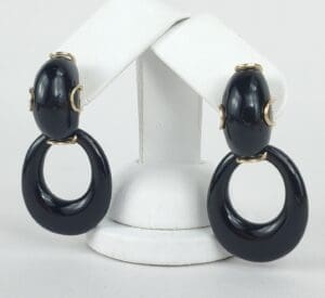 Black hoop earrings with gold accents displayed.