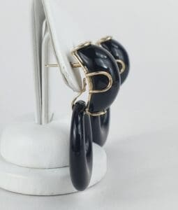 Black and gold hoop earrings on stand.
