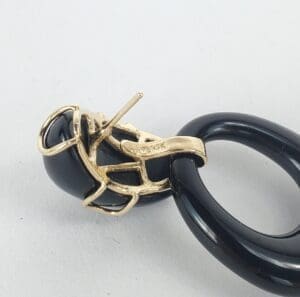 Gold and black looped jewelry piece.