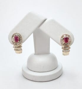 Gold earrings with red gemstones on display.