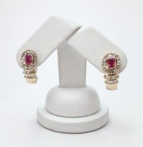 Gold earrings with red gemstones displayed elegantly.