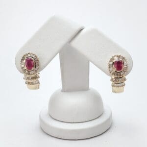 Gold earrings with red gemstones on display.