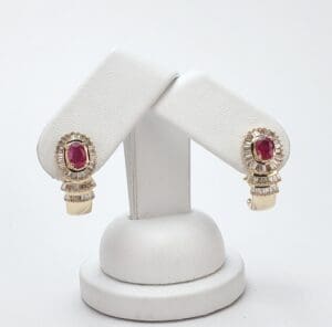 Gold earrings with red gemstones on display.