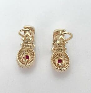 Gold earrings with red gemstone accents.