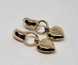 Gold heart-shaped earrings on white background.