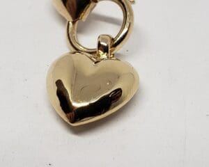 Gold heart-shaped pendant on white background.