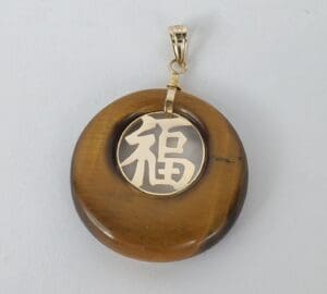 Brown pendant with Chinese character design.