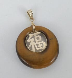 Brown pendant with gold Chinese character.