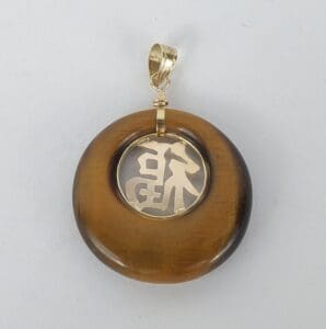 Tiger's eye pendant with gold Chinese character.