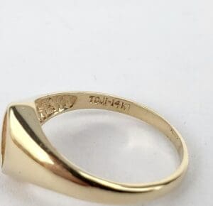 Gold ring with engraved markings inside band.