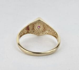 Gold ring with pink gemstone detail.