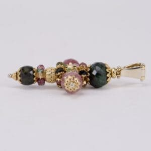 Multicolored beaded pendant with gold accents.
