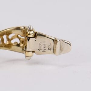 Gold bracelet clasp with engravings.