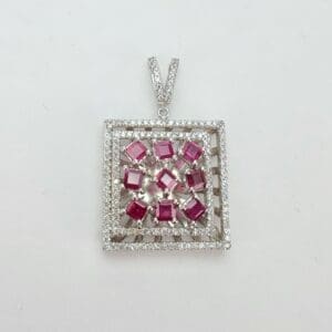 Square pendant with red gemstones and diamonds.