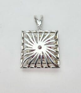 Silver square pendant with abstract design.