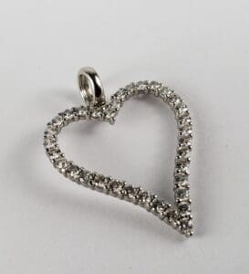 Heart-shaped diamond pendant on white background.