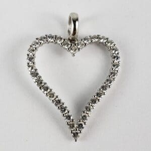 Heart-shaped diamond pendant on white background.