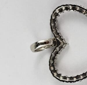 Silver heart pendant with loop attachment.