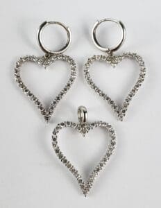 Heart-shaped silver earrings and pendant set.