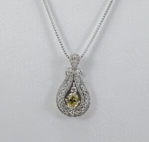 Diamond pendant necklace with yellow gemstone.