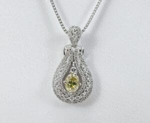 Silver necklace with green gemstone pendant.
