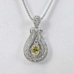 Silver necklace with green gemstone pendant.