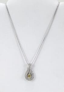 Silver necklace with yellow gemstone pendant.