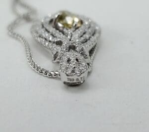Diamond pendant with intricate design on chain.
